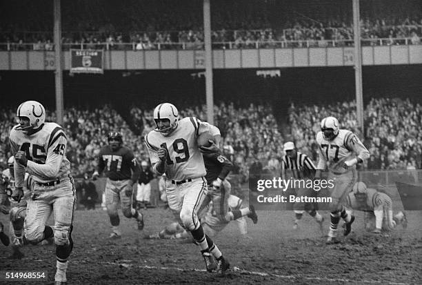 With L.G. Dupre leading the way, Johnny Unitas of Baltimore breaks through the Giant's line to ramble 16 yards in the second quarter. Shortly after...