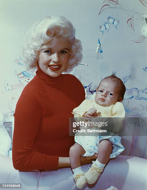 American movie actress and sex symbol Jayne Mansfield smiles while holding her son Miklos Hargitay.