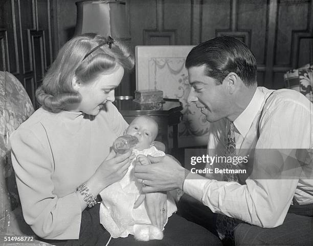 While her famous husband looks on, Mrs. Joe DiMaggio, , feeds Joe DiMaggion 3rd, at their New York apartment. Young Joe is one month old. His father,...