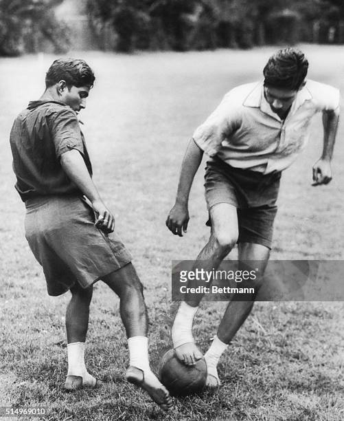 Playing in bare feet, two members of India's Olympic football team practice at the Imber Court Sports Club for their match on July 16th, 1948 with...