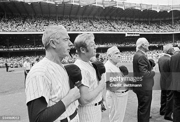 Joe DiMaggio, Mickey Mantle, and Casey Stengel salute the flag during the National Anthem played before the annual old-timers game at Yankee Stadium...