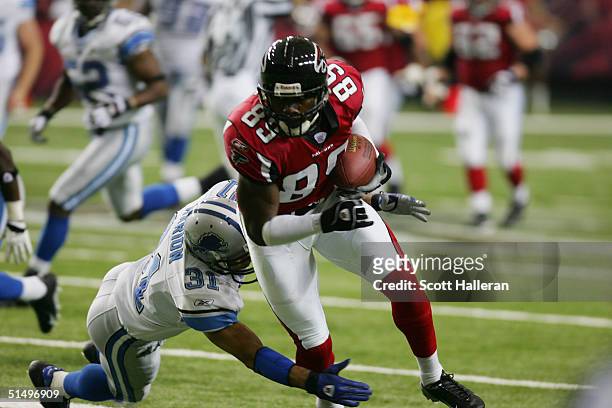 Wide receiver Dez White of the Atlanta Falcons attempts to elude cornerback Brock Marion of the Detroit Lions during the game at the Georgia Dome on...