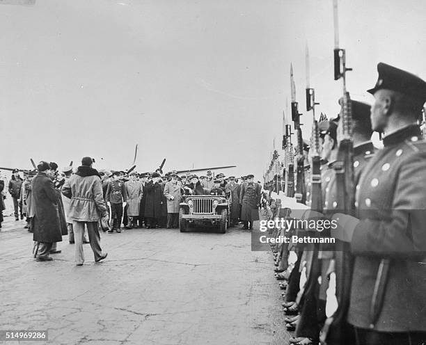 President Franklin D. Roosevelt, in his Jeep, reviews the Russian Guard of Honor drawn up at the Yalta Airport in his honor. Others in the group...