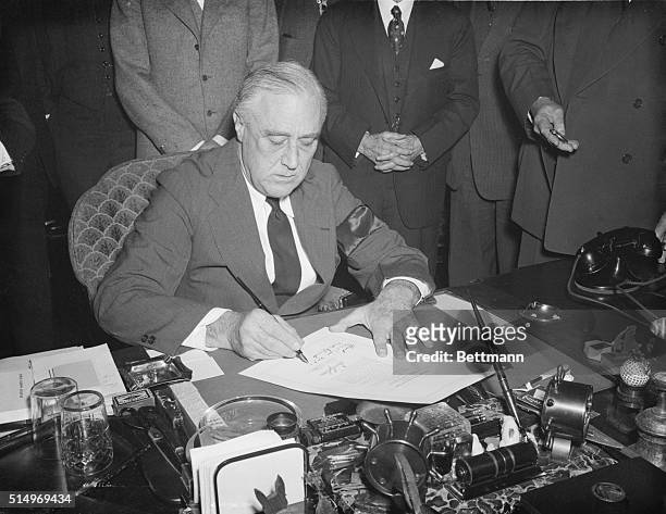 President Roosevelt signs the declaration of war against Japan after the attack on Pearl Harbor.