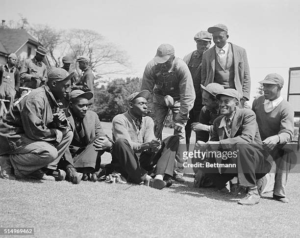 Gene Sarazen's favorite caddy Stovepipe , is showing his fellow caddies the club with which Gene made the double eagle in 1935. Sarazen is among the...