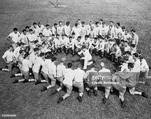 Coach Frank Leahy of Notre Dame is the center of this circle formed by about 70 candidates for places on the "Irish" football team for the 1947...