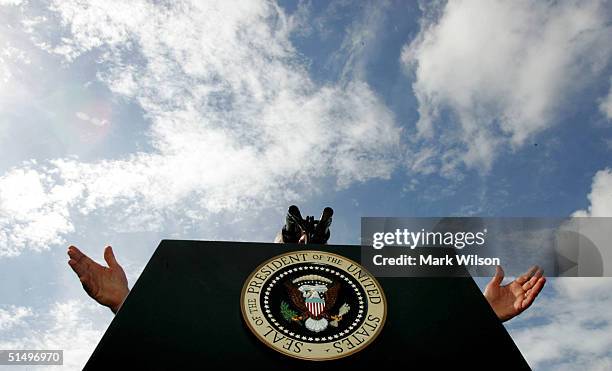 President George W. Bush raises his hands behind the lectern while speaking at a campaign rally at Sims Park October 19, 2004 in New Port Richey,...