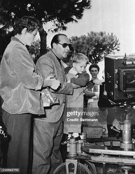 Visiting Daddy's Office. Santa Marinella, Italy: Robertino Rossellini watches a movie camera with fascination while being held by his director...