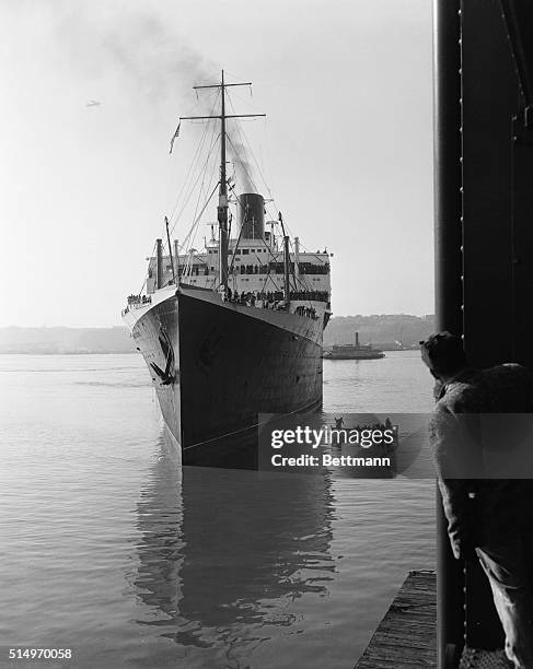 The French liner Ile de France stands in the harbor waters at Pier 88, having negotiated precision turns and maneuvering without the aid of tugboats,...