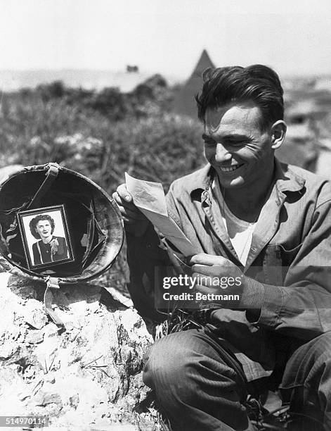 Marine Private First Class Patrick J. Carr, stationed in Okinawa, Japan at the end of World War II, smiles as he reads a letter from Stella Norek in...