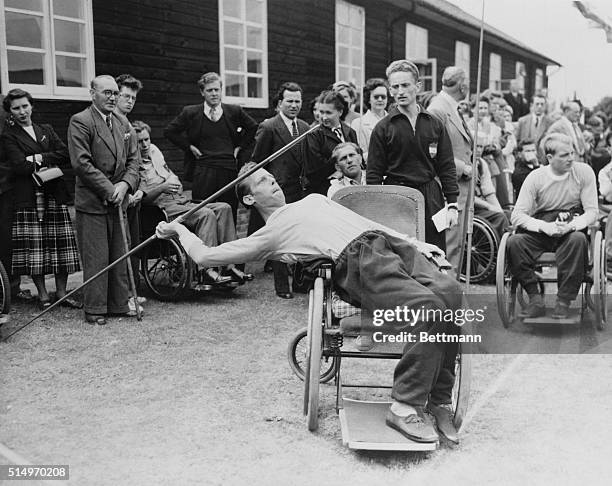 Dutch athlete Joep de Beer, leans into the javelin from his wheelchair during the 3rd International Stoke Mandeville Games, 2nd August 1954. It was...