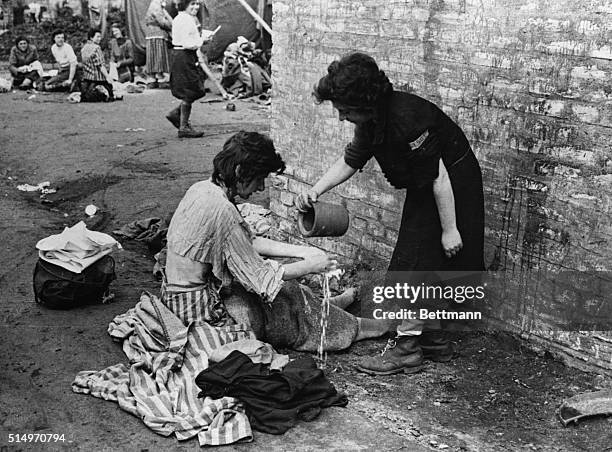 Two women make the best of a tin of water for washing.