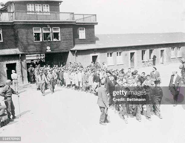 Internees, many of the children, at the Buchenwald concentration camp near here, march from the camp to receive treatment at an American hospital...
