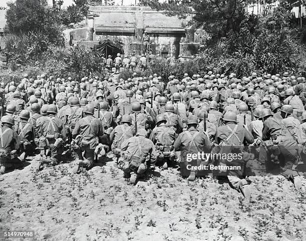 Fighting men of the 165th regiment, 2nd battalion of the 27th division kneel during memorial services for the late President of the United States,...