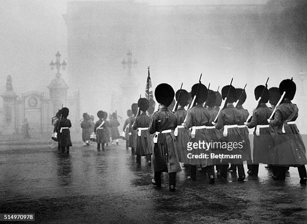 As the dense blanket of fog hides most of London from view, Scots Guards march towards Buckingham Palace to take up sentry duty. With the capital...