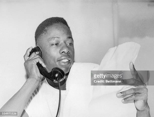 National League Most Valuable Player recipient Hank Aaron talks with a friend on his hotel telephone after the Milwaukee outfielder received the...