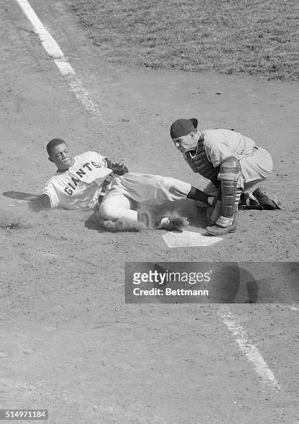 New York Giant's Willie Mays is nabbed at home by St. Louis Cards backstop Bill Sarni, as he tries to score from first base on don Mueller's double...