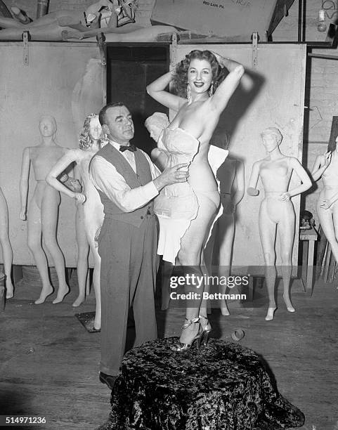 Designer James Berry strips tape and and jersey form from the body of Burlesque queen Tempest Storm in preparation for a manikin of the buxom...