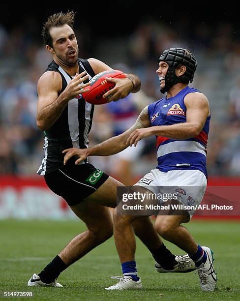 Steele Sidebottom of the Magpies and Caleb Daniel of the Bulldogs compete for the ball during the 2016 NAB Challenge match between the Collingwood...