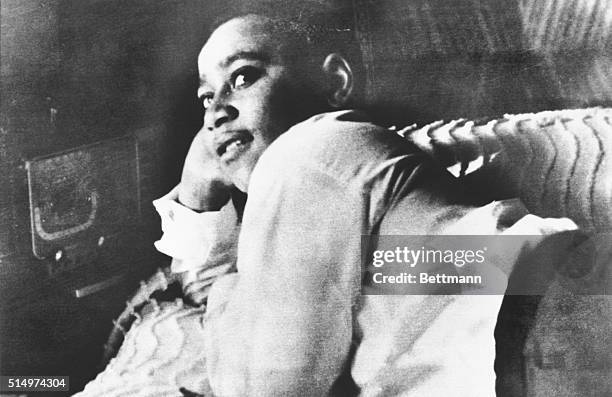 Emmett Till is shown lying on his bed.