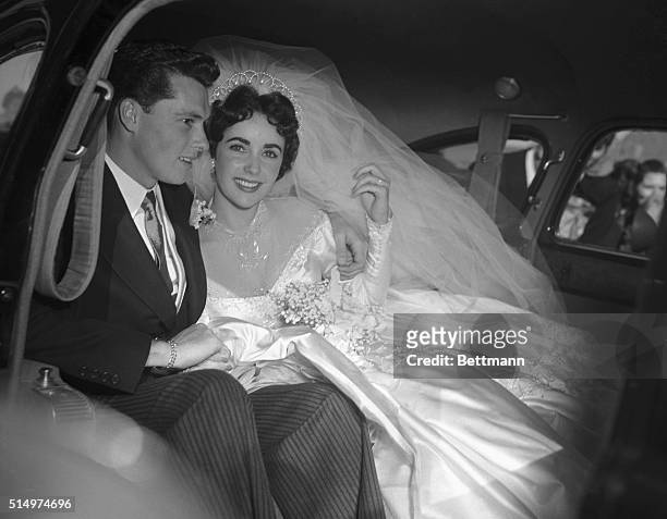 Actress Elizabeth Taylor and her groom, Conrad "Nickie" Hilton, Jr. In the limousine that will take them to their wedding reception at the Bel-Air...