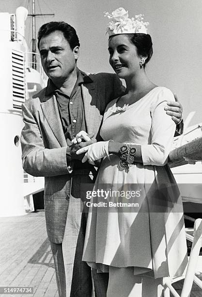 Elizabeth Taylor and her husband Mike Todd returned home, 7/10, holding hands aboard the liner Liberte. They laughed when reporters suggested their...