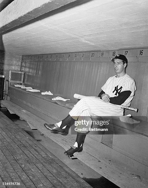 Joe DiMaggio, brightest star of the N.Y. Yankee baseball constellation and sparkplug of the club, is shown in the club dugout today as he donned...