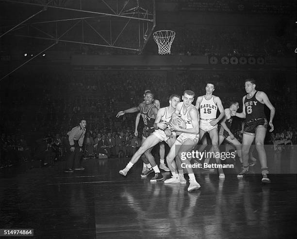 New York, New York: Three Bradley men are shown huddling around the ball while CCNY men Ed Warner and Ed Roman close in on them, during the first...