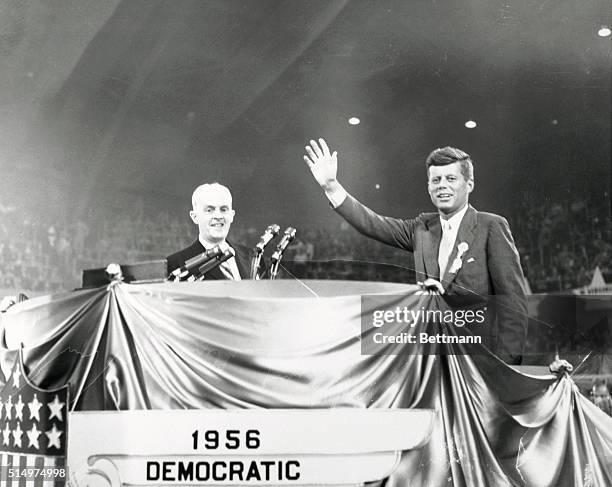 Senator John Kennedy waves to the crowds as he reaches the speaker's platform to narrate the keynote film at the evening session to the Democratic...