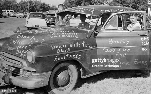 Roy Lee Howlett stands beside a car painted with signs protesting Negro students entry into Mansfield High School. The car was placed at the entrance...