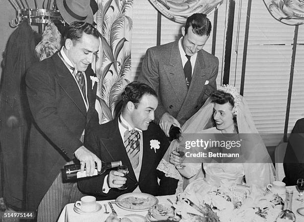 Best man Yogi Berra , New York Yankee catcher, and St. Louis Cardinal outfielder Stan Musial fill the glasses for a toast at the wedding breakfast of...