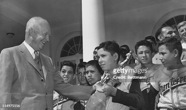 Ike Presents Trophy to Little League Champions. Washington: President Eisenhower presents the golden trophy of the Little World Series to the proud...