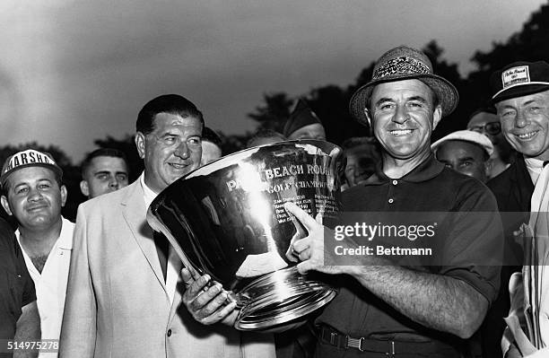 Veteran golfer Sammy Snead points proudly to his trophy, after winning the Palm Beach Round Robin Golf Tournament at the Wykagyl Country Club here,...