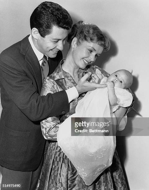 Camera Debut. Hollywood, California, USA: Eddie Fisher and wife, Debbie Reynolds, gaze proudly at their baby daugher, Carrie Frances Fisher, here...