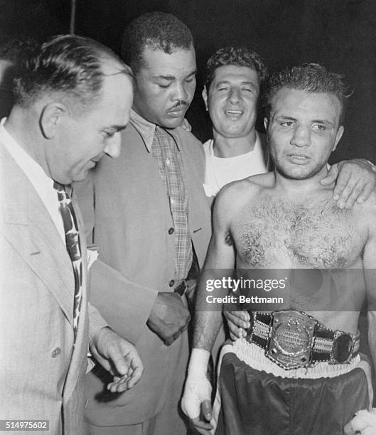 Bronx battler Jake LaMotta is moved to the verge of tears, as retired world champion Joe Louis adjusts the championship belt. Jake won the World's...