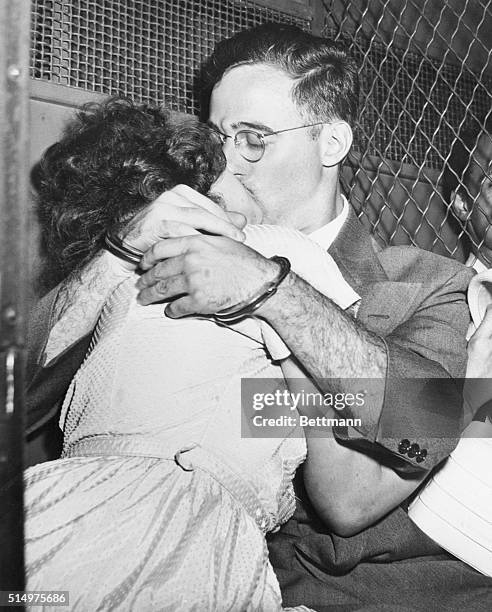 Bound for separate cells, handcuffed Julius Rosenberg and his wife, Ethel, share a fervent kiss in prison van outside Federal Court after arraignment...