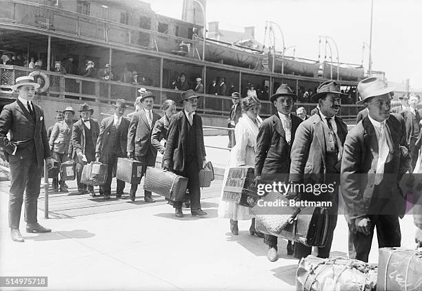 IMMIGRANTS ARRIVING IN U.S.A., ELLIS ISLAND. MAY 27, 1920. INP B/W PHOTOGRAPH.