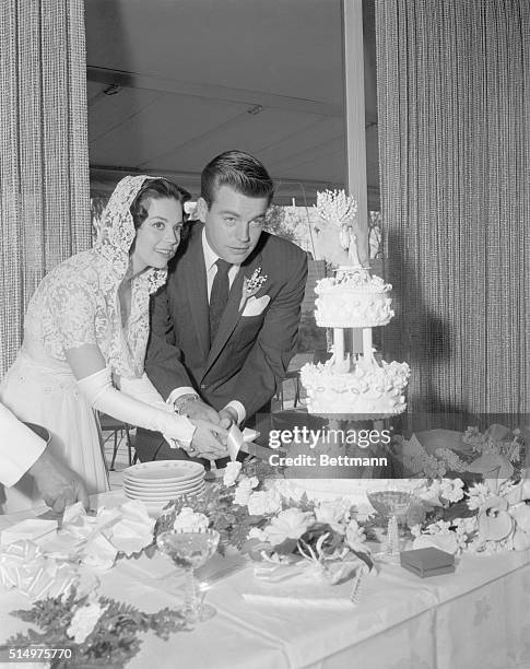 Scottsdale, Arizona: screen stars Natalie Wood and Robert Wagner cut their wedding cake at reception following simple wedding ceremony attended only...