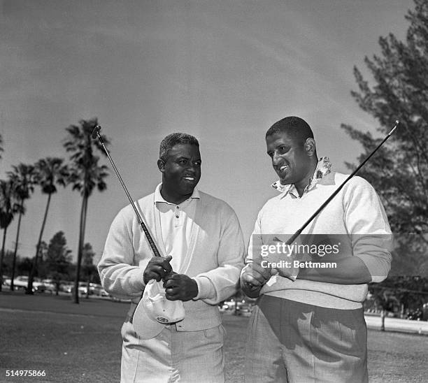 Jackie Robinson, left, former infielder for the Dodgers baseball team, lately of Brooklyn, and his onetime teammate pitcher Don Newcombe, get...