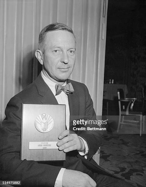 Banquet of National Book Awards. Photo shows John Cheever with his award plaque.