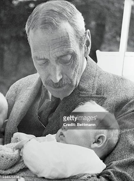 Newborn Princess Margrethe as a baby, is shown in the arms of her grandfather, the late King Christian the 10th.