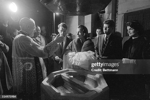 Democratic Presidential nominee shown during the baptism of his first child in this December 13th, 1957 file photo. Archbishop Cushing is baptizing...