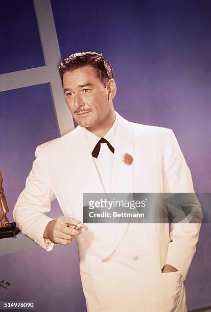 Actor Errol Flynn who often portrayed "swashbucklers" poses in a white tuxedo.