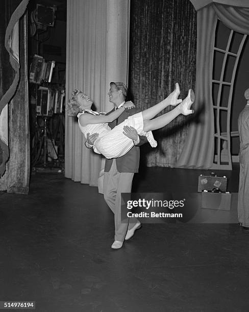 Doris Day being carried by her partner Gene Nelson onto the set as part of an "Off Stage" gag prior to going into their very active routine shown...