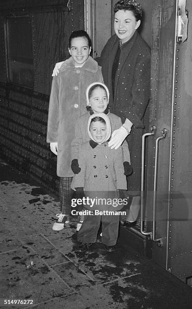 Standing near the door of the 20th Century Limited, singer Judy Garland poses with her three children on arrival at Grand Central Station. She was...