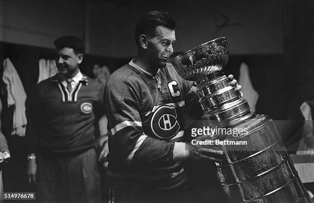 Maurice "Rocket" Richard, star of the Montreal Canadiens, gets acquainted with the Stanley Cup here April 20th. The Canadiens won the cup by beating...