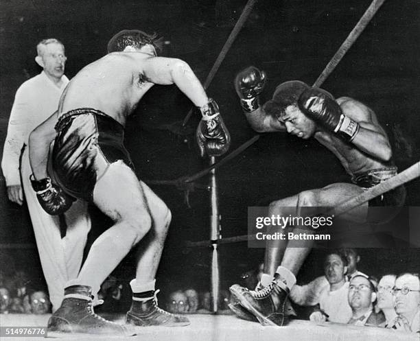 Victorious in 129 successive fights, including 40 as a pro, Ray Robinson falls through the ropes of a Detroit ring, under the impact of Jake...