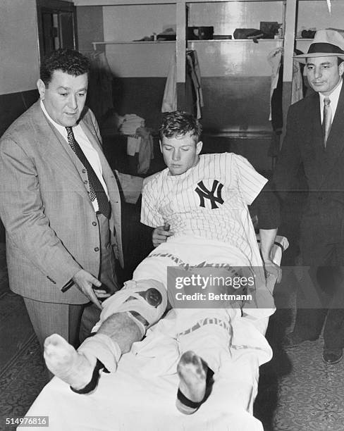 Right Fielder Mickey Mantle of the New York Yankees has his right knee examined here by Dr. Sidney Gaynor in the team's dressing room at the Yankee...