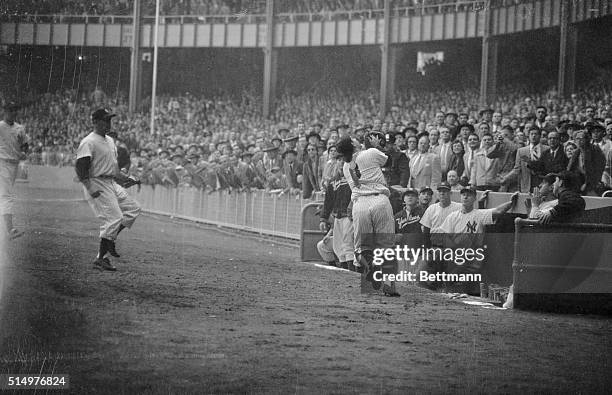 Yogi Berra, New York Yankee catcher, clutches the game ending out, a pop fly off the bat of Red Sox outfielder Ted Williams, as pitcher Allie...