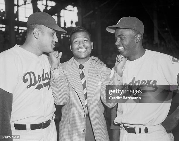 Middleweight Champ Sugar Ray Robinson called on a pair of Dodger Champs at Ebbet's Field today to bestow love -pats with his championship fists for...